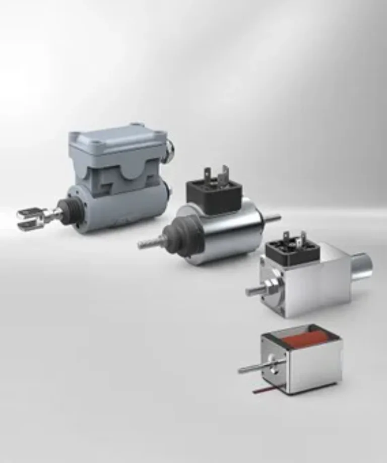 Vier verschiedene industrielle Elektromagnete auf hellgrauem Hintergrund, darunter ein Spulenaktor und ein Hubmagnet.