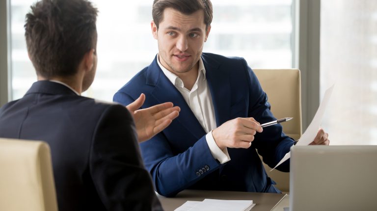 Successful businessman clarifying provisions of contract with business partner, discussing terms of agreement, explaining strategy or financial plan. HR manager asking job candidate about his resume
